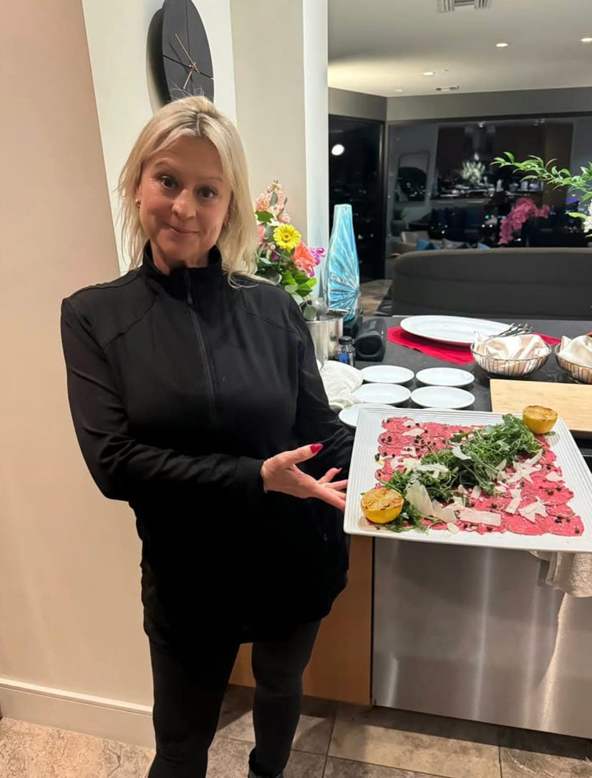 Emily presenting a beef carpaccio platter at a private event
