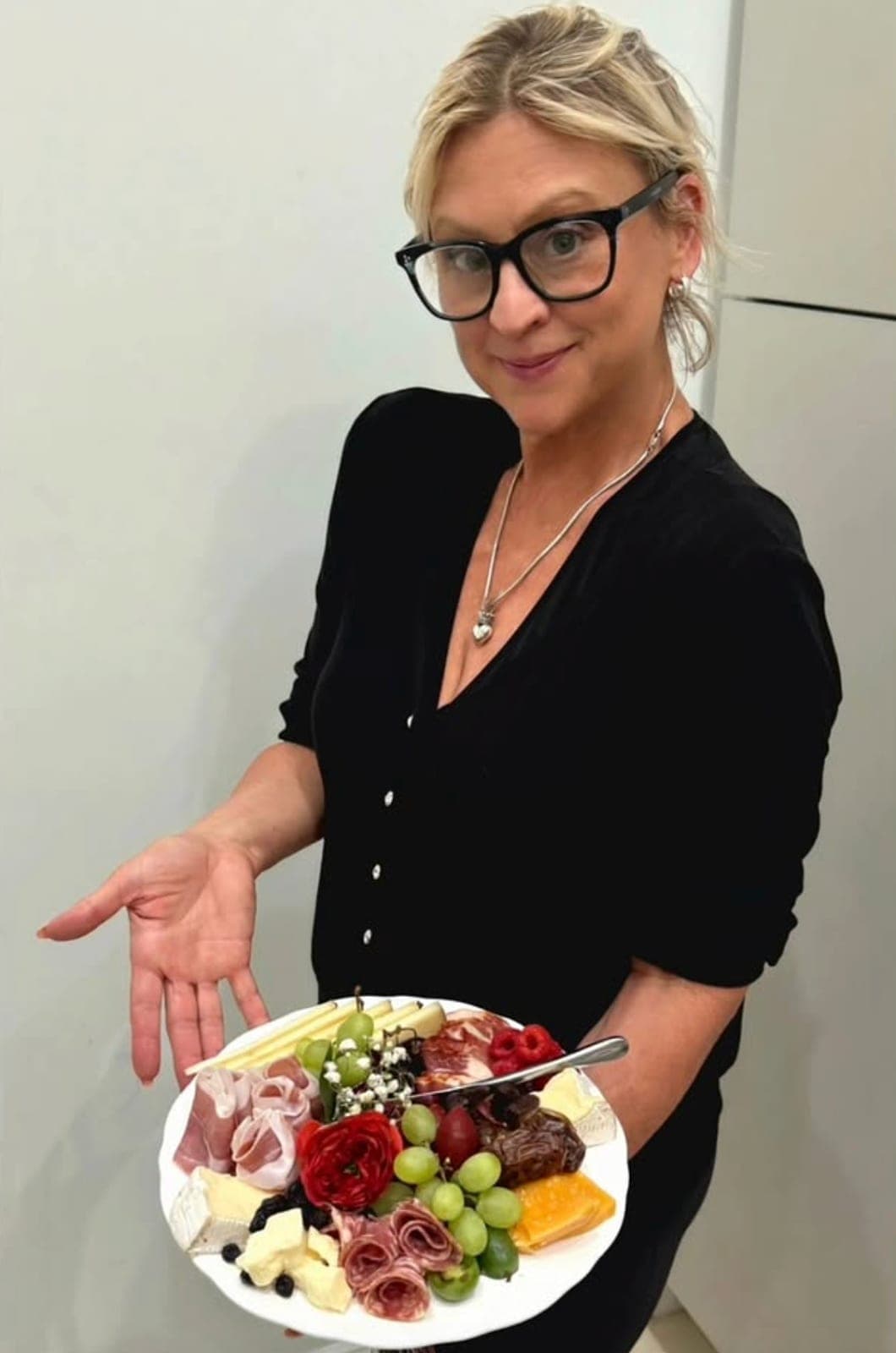 Emily holding a charcuterie and cheese plate