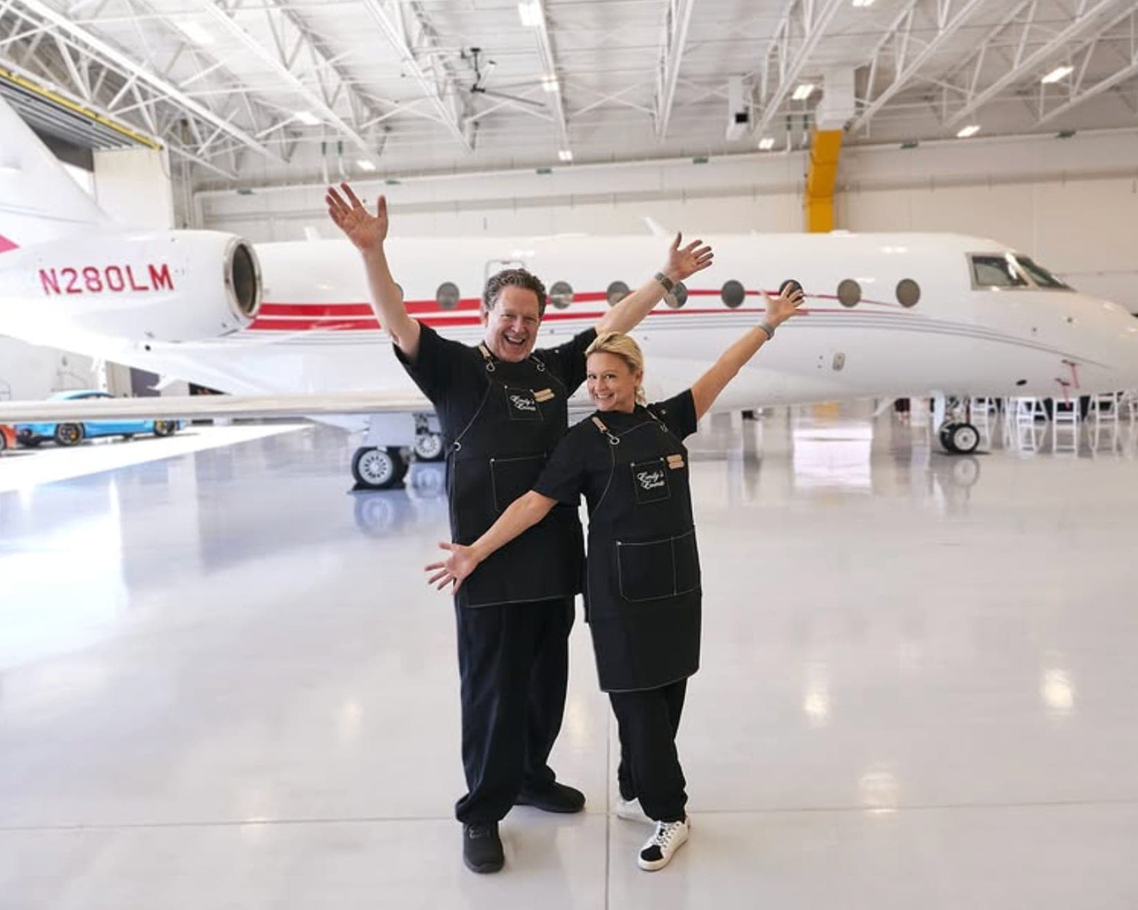 The service team celebrating in front of a private jet