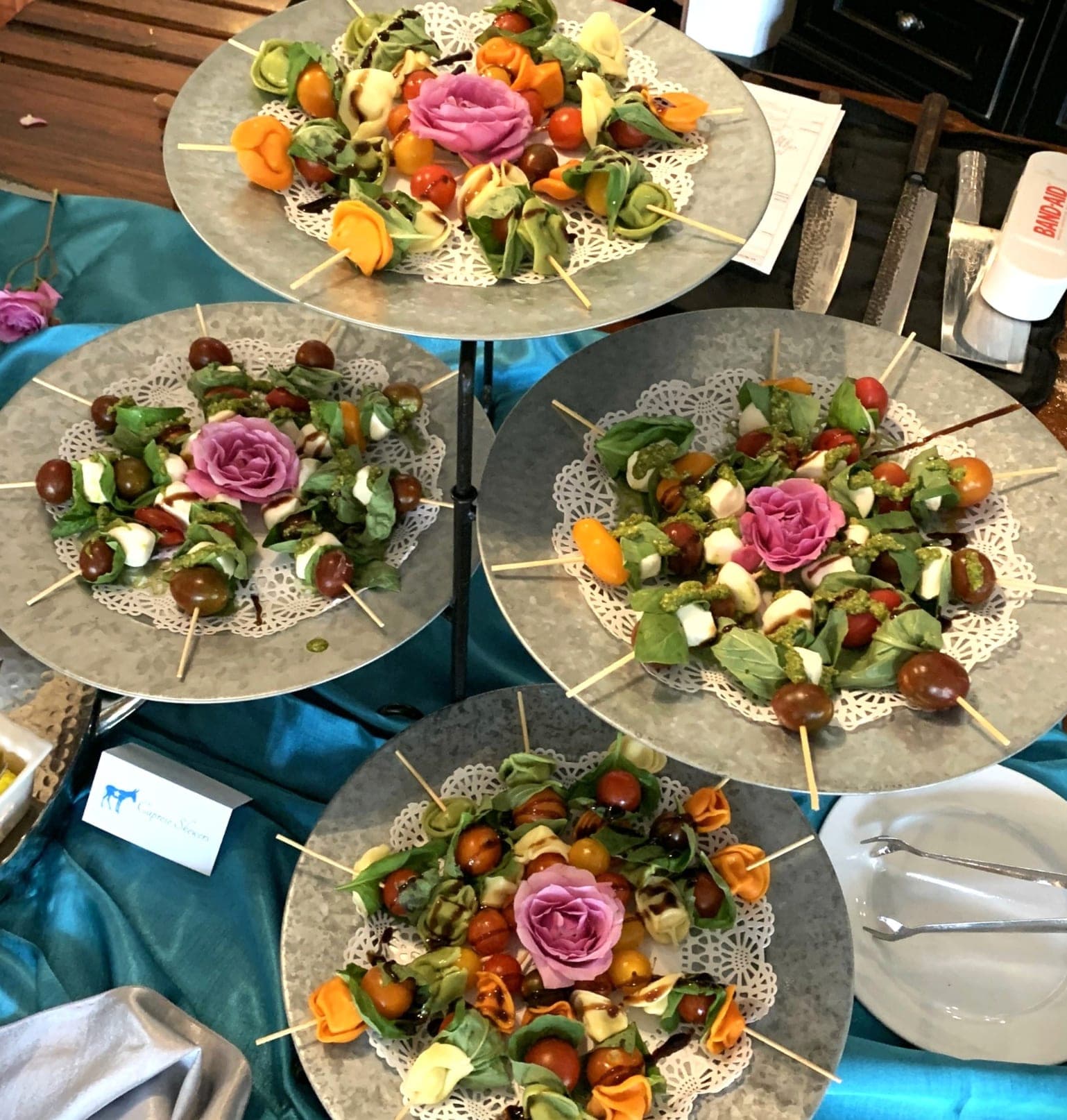 Tiered plates of caprese skewers garnished with roses