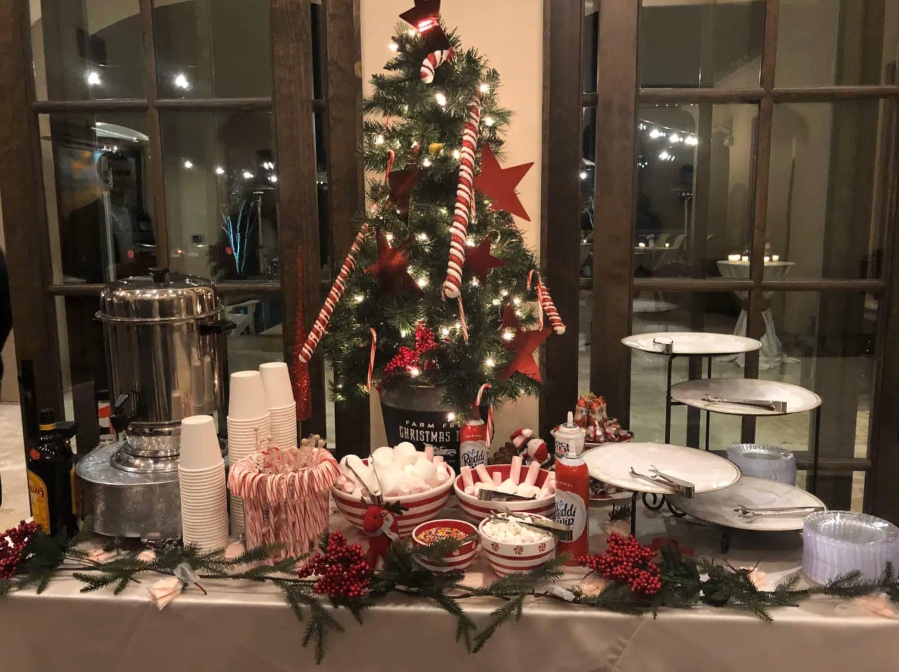 A holiday hot-cocoa bar with a decorated Christmas tree and candy canes