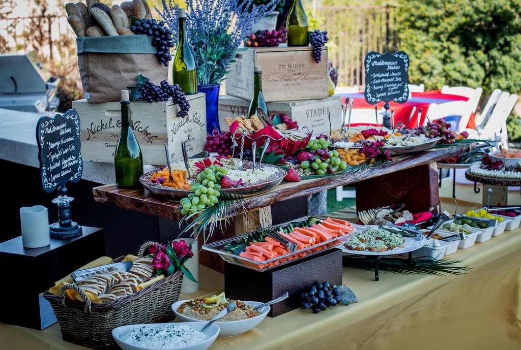 Outdoor wine and charcuterie buffet under garden trees